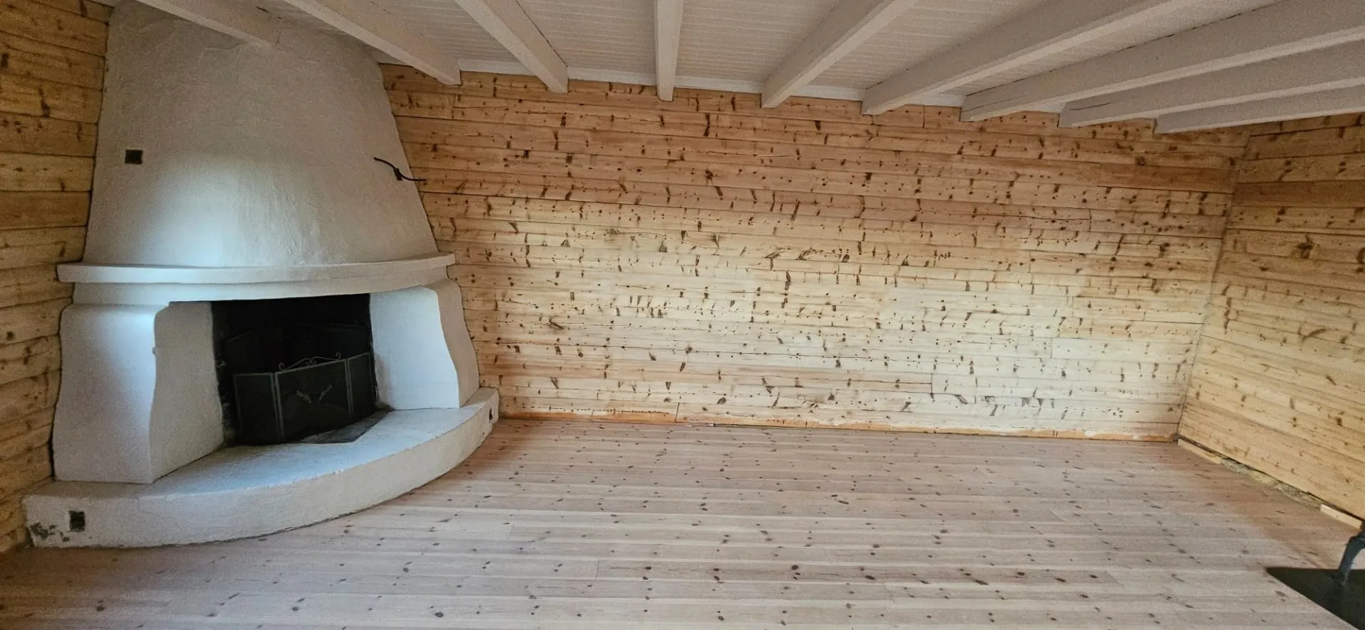 The same room after sandblasting: light, bare timber walls