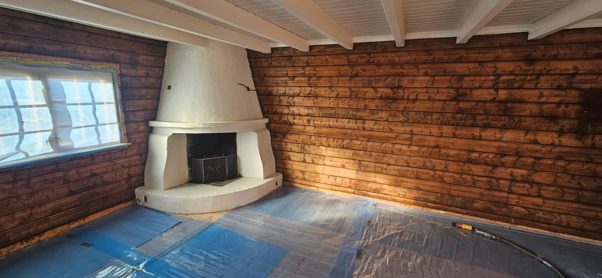 A log room before: the walls stained almost black