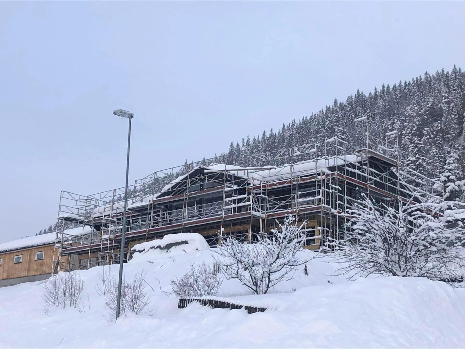 A large building wrapped in scaffolding in deep snow